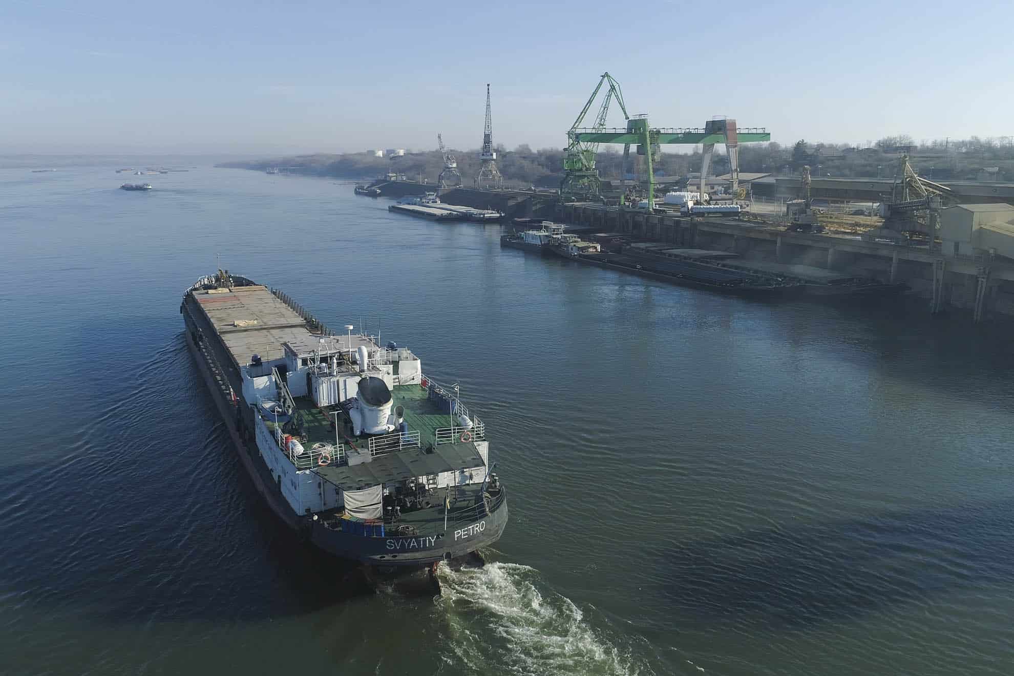Aerial view of a port on a river with cargo ships and railway lines