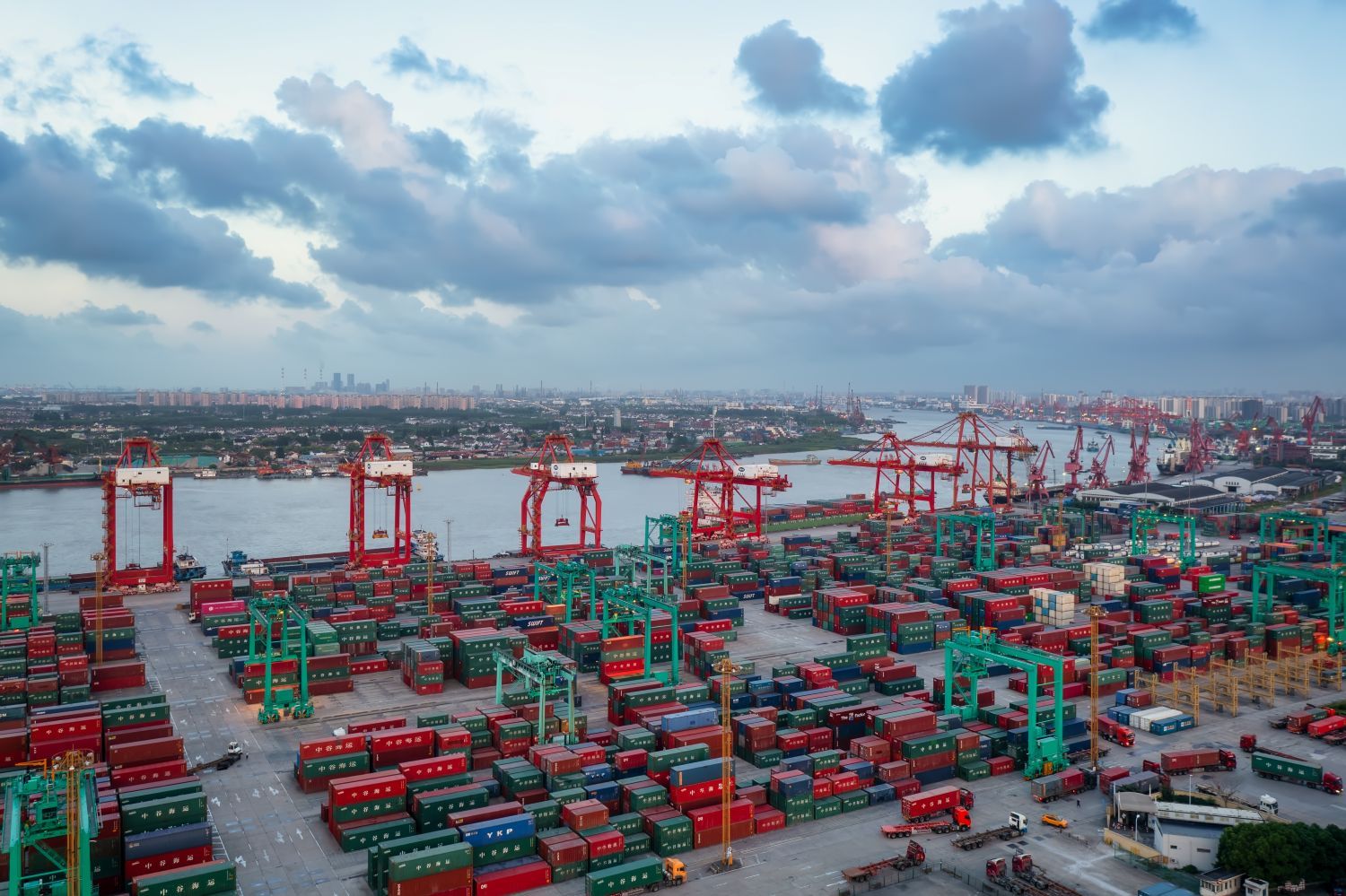 Container ships at a busy port in Asia, with cranes loading and unloading cargo.