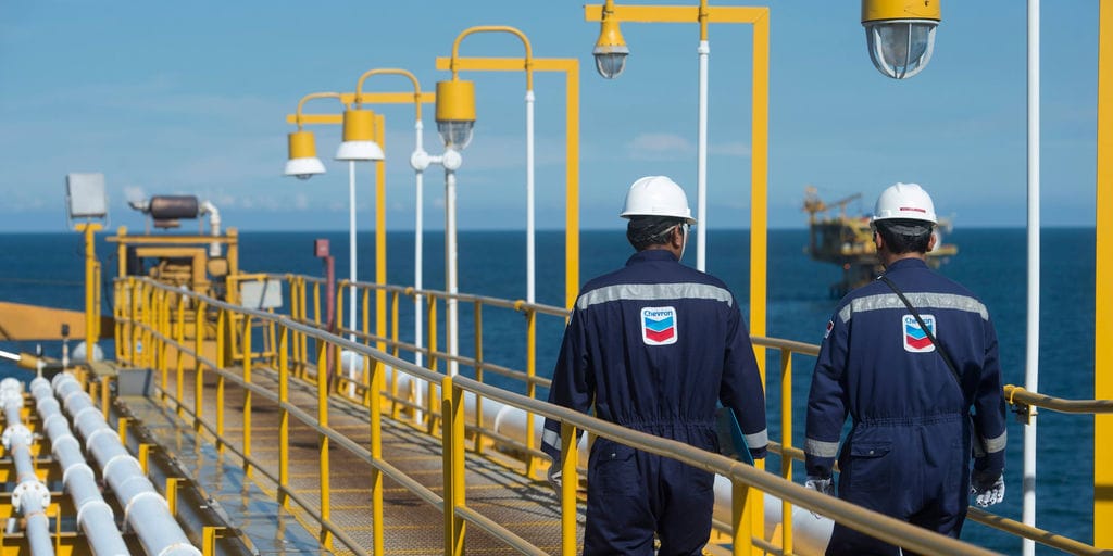An offshore oil platform operating in deepwater, with a clear sky and calm sea.