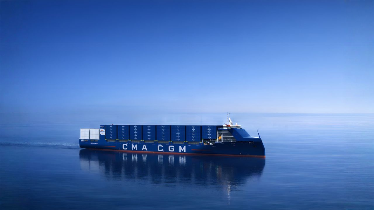 A large container ship, possibly a CMA CGM vessel, sailing on the open sea.