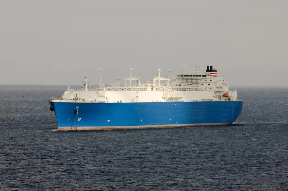 A large LNG carrier with wing sails on its deck.