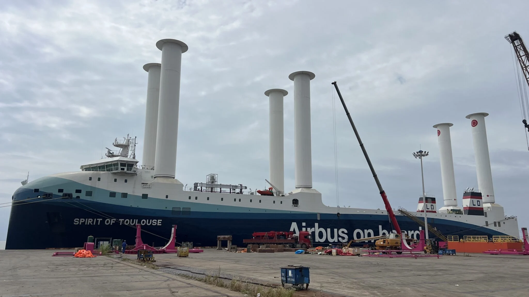 A large roll-on/roll-off vessel equipped with multiple towering rotor sails.